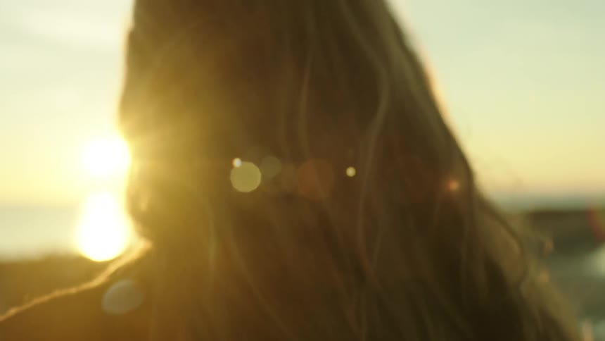 The sun shines down on a woman on the beach