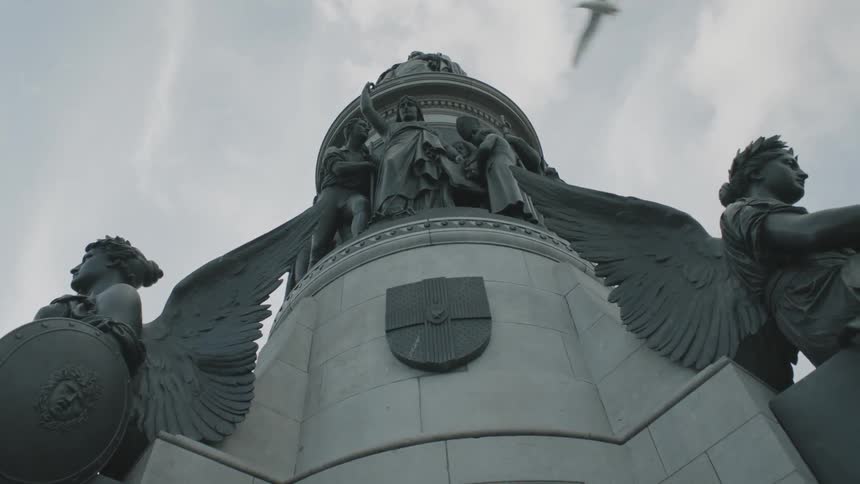 A statue with angels and representations of other people