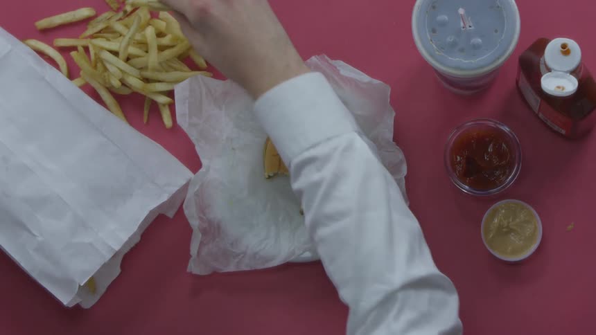 A person is eating a burger and fries