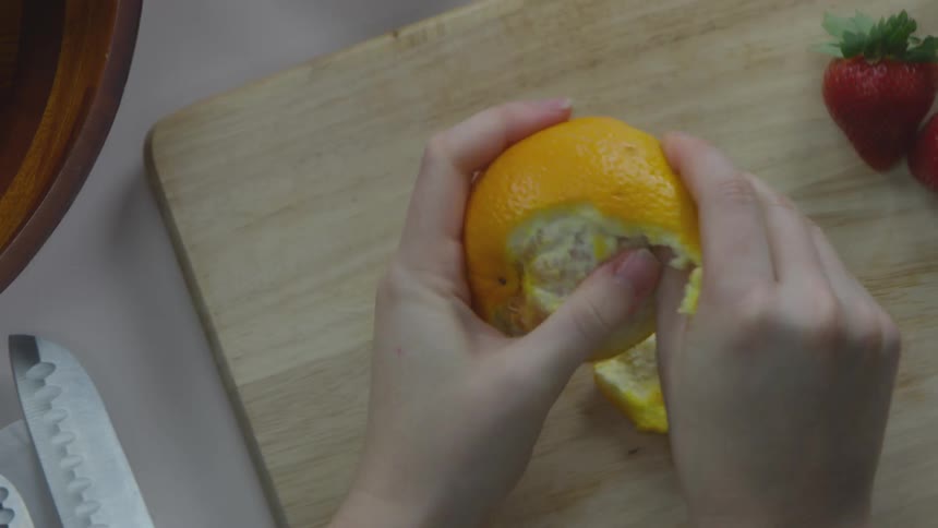 A person peeling an orange