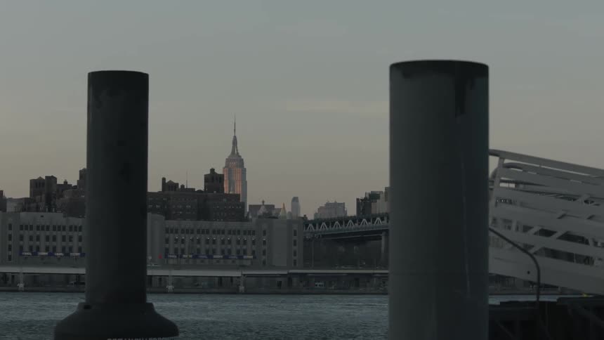 A city sits over a body of water on a cloudy day