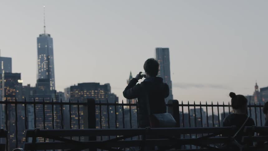 Young man takes a picture of a city
