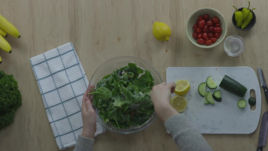 A person is mixing a salad