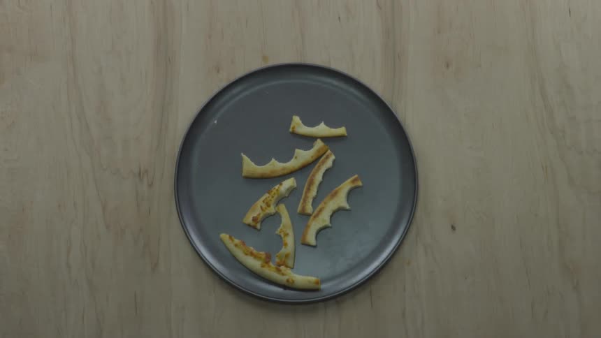 People toss uneaten pizza crusts onto a metal pizza pan