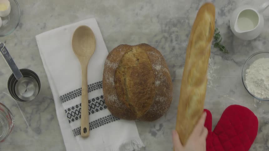 Bread being placed on a marble countertop