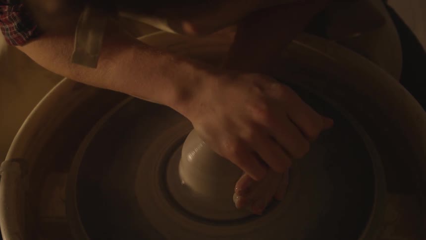 A person is making a bowl out of clay