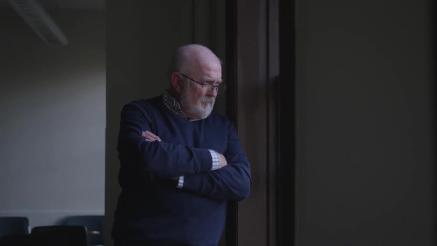 A man is looking out a window
