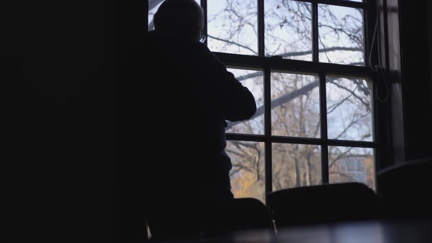 A man is looking out a window