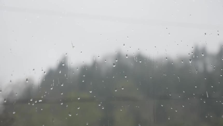 It drizzles and raindrops on the window on a cloudy day