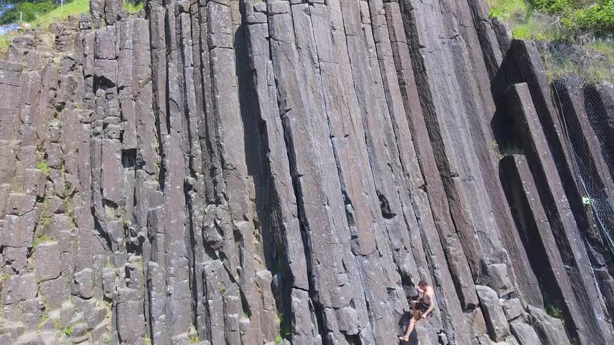 A person is climbing down a cliff