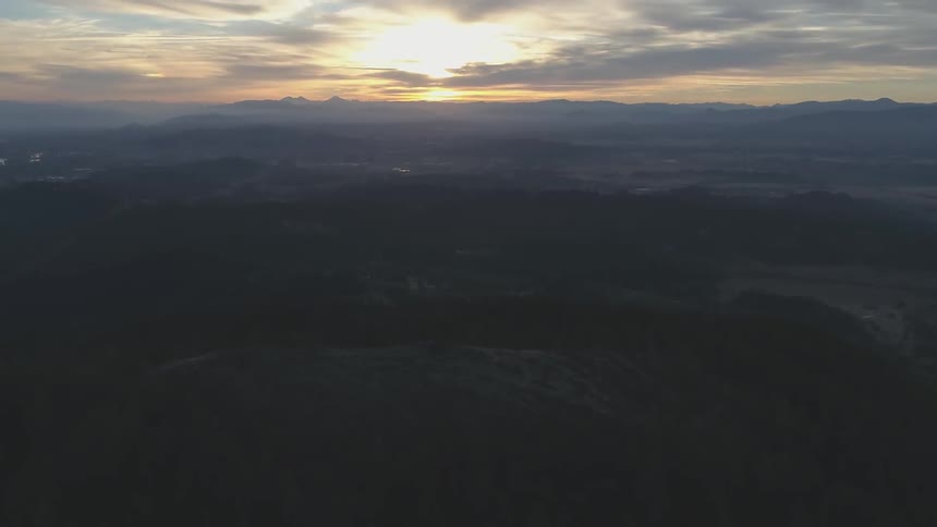 Sun goes down behind mountains on a cloudy day