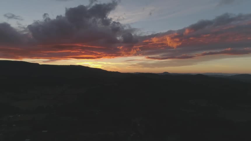 Sun sets behind mountains on horizon