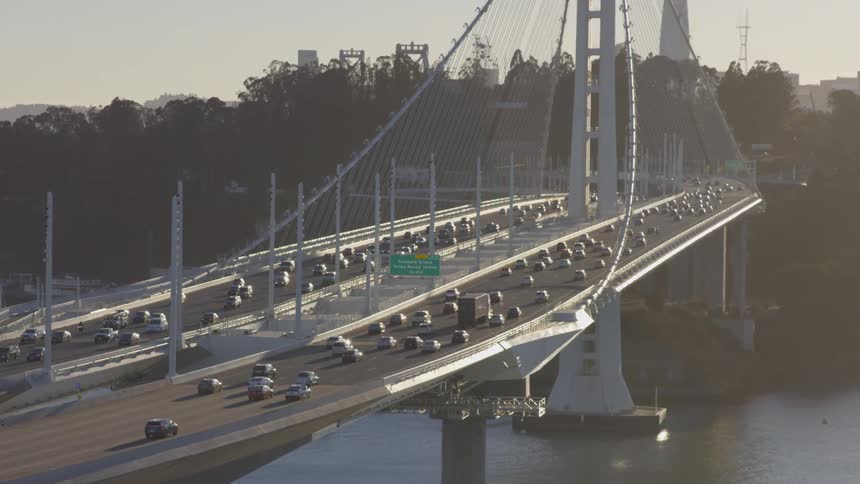 Vehicles traveling over a large bridge spanning a river