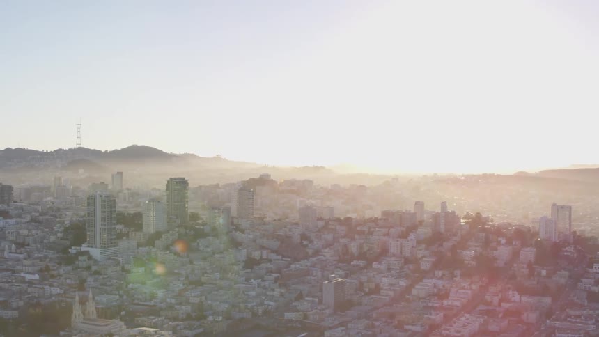 A hazy city skyline with hills in the distance