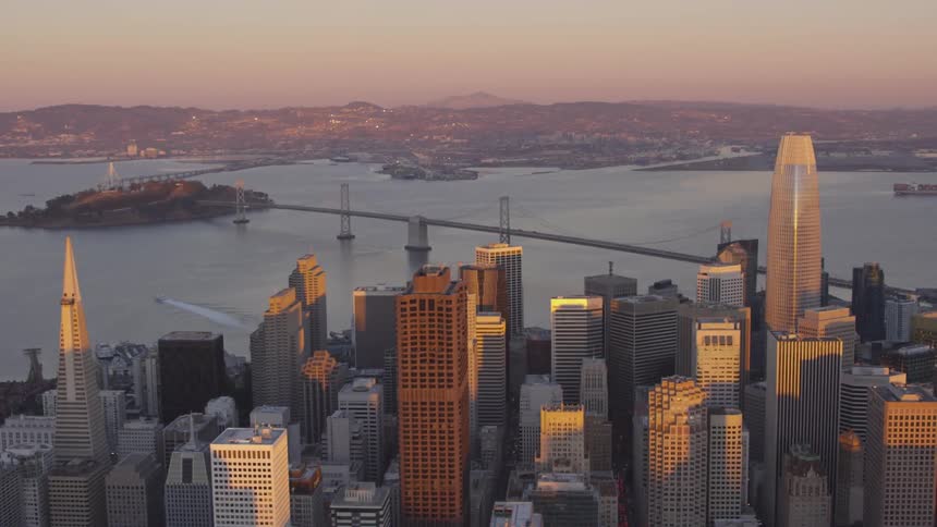 Sunlight illuminates city skyscrapers at sunset
