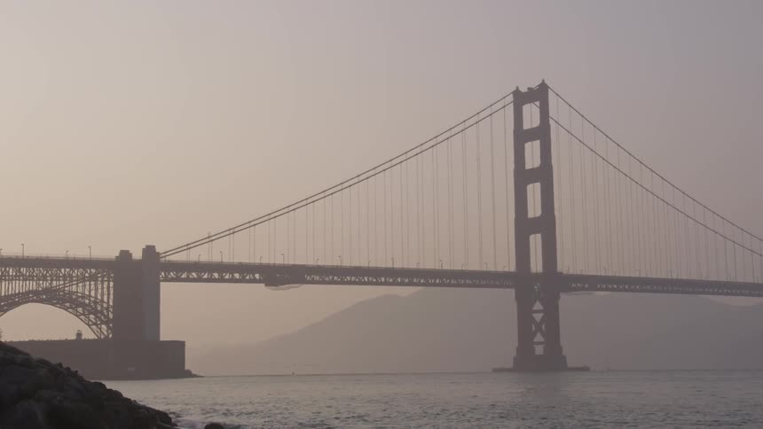 A bridge that is over water near a mountain