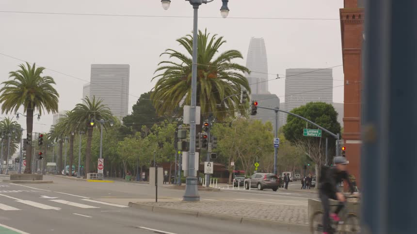 Person bicycles along wide urban street