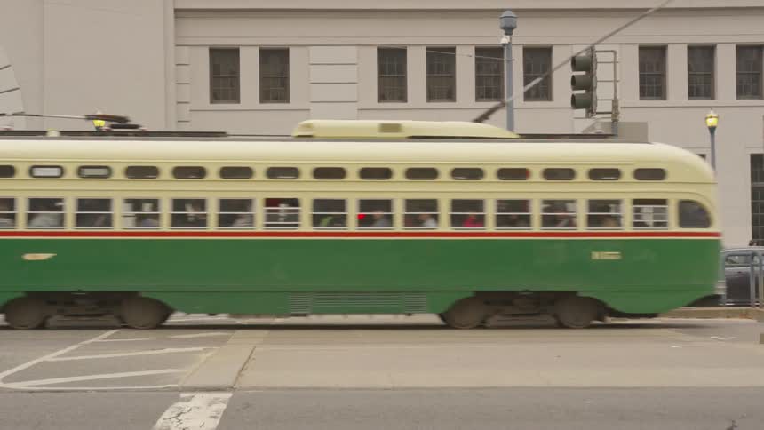 A trolley cars trucks and bikes all travel on a city street