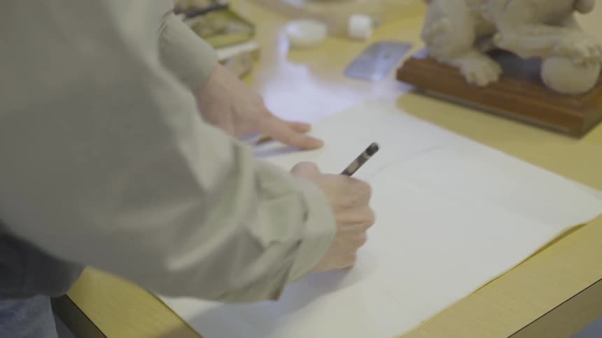 Man sketches on paper