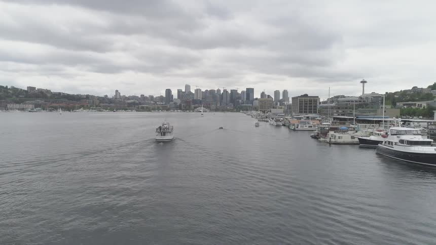 Boats traveling in the harbor of a big city