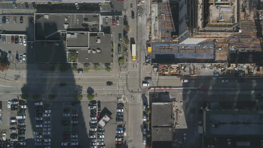 Top down view of an intersection in the middle of a big city with lots of cars