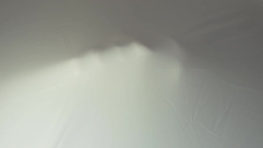 A shape moves under a bed sheet