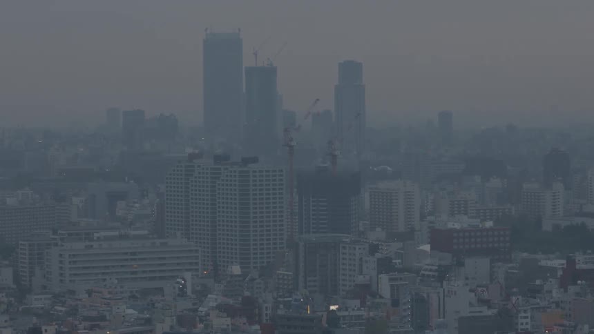 A city shrouded in smog pops in and out of focus