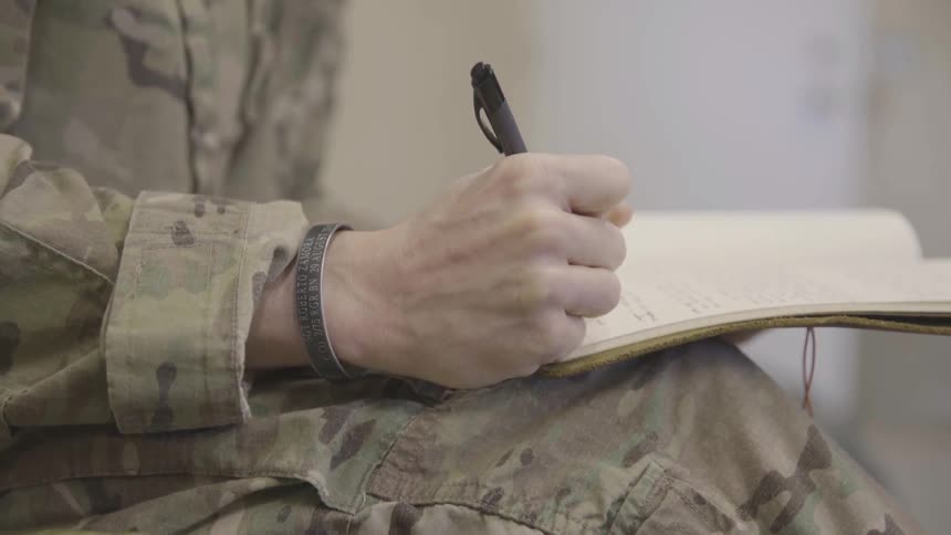 Soldier writing in a notebook