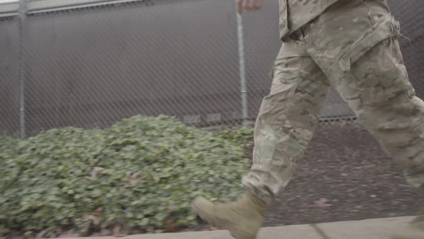 An army man is walking outside