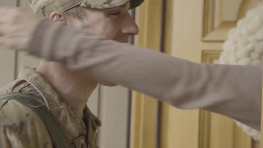 A military man hugging and kissing a woman