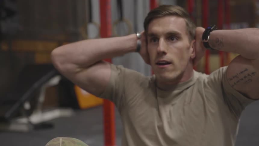 Soldier does sit ups in a gym