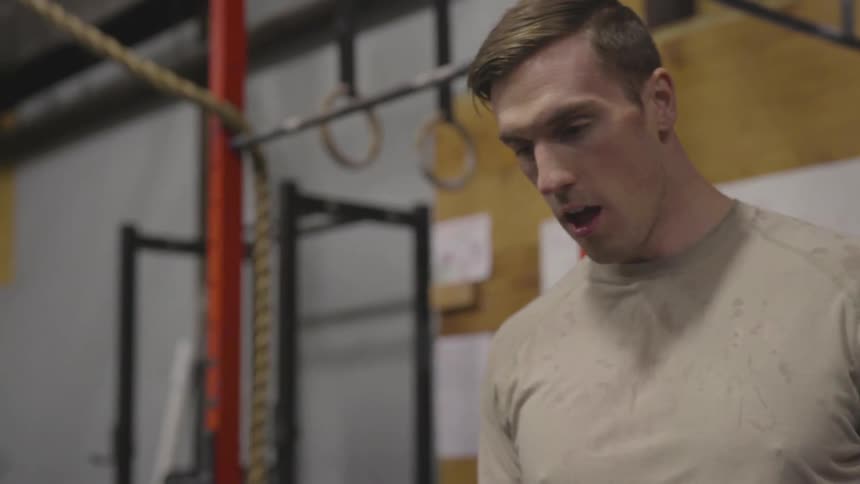 Man bending over catching his breath at the gym