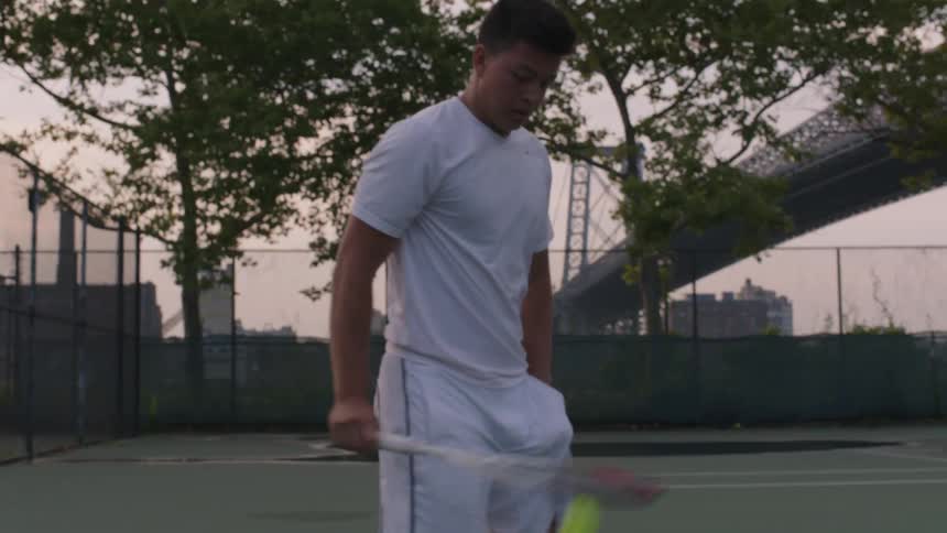 Man practices his tennis serve