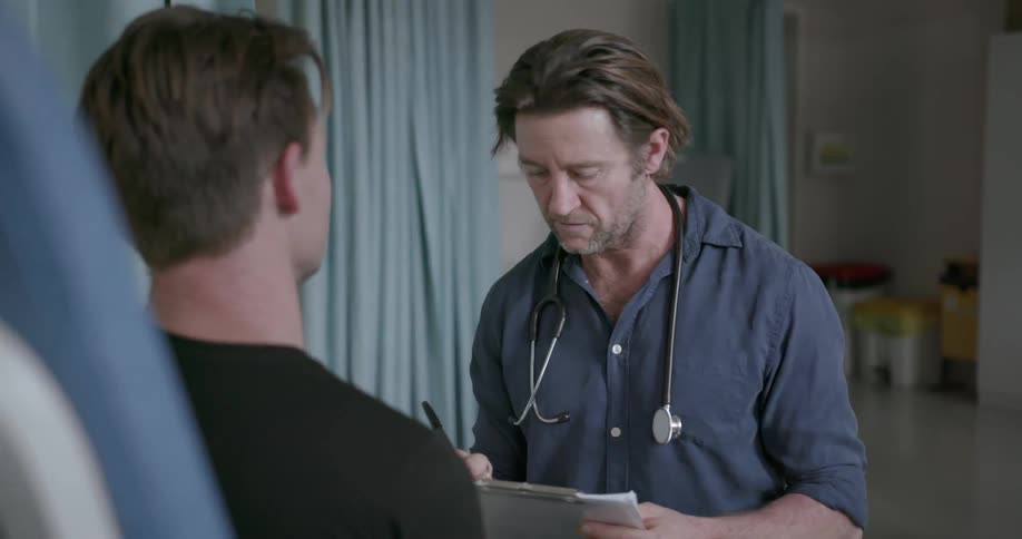 Doctor takes notes while talking to a patient