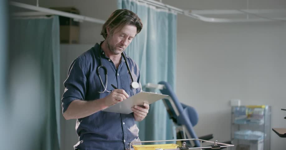 A doctor makes some notes on a chart