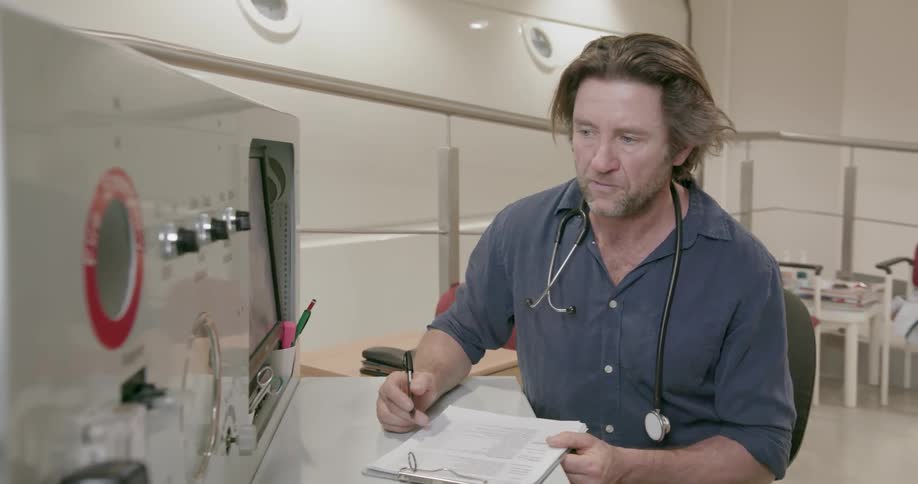 A man looks at a device and makes notes