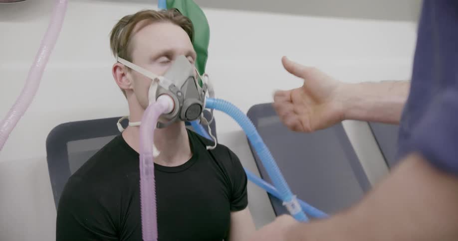 A doctor affixes a breathing mask on a patient in an air cabin