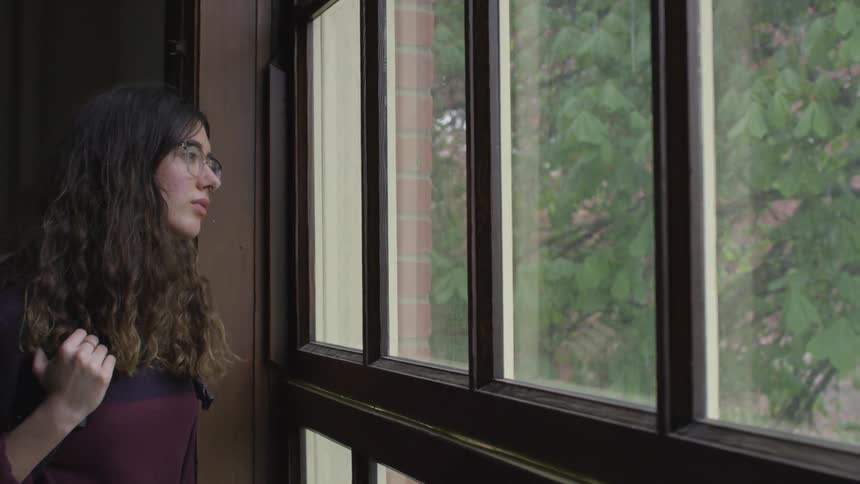 Woman looks out a window
