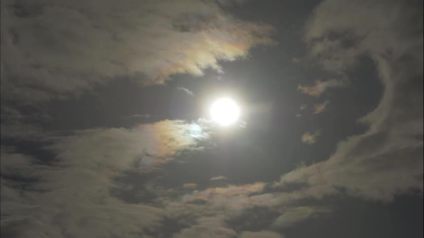 The sun breaking between clouds in the sky