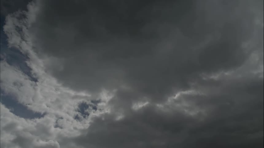 Dark storm clouds passing the sun
