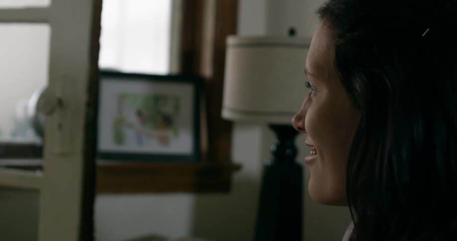 Close up of a woman staring into mid frame and smiling