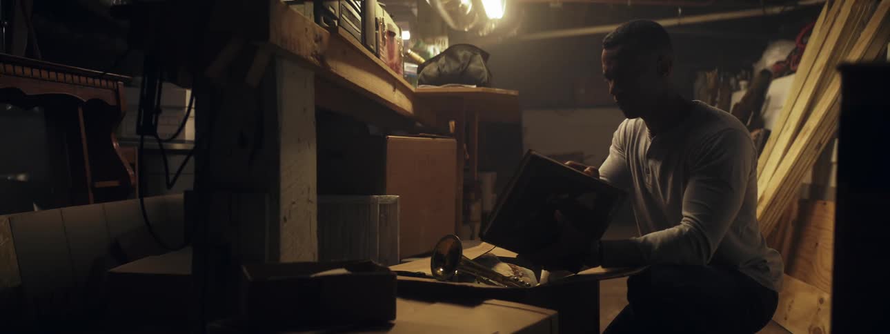 A man is in a workshop looking through items