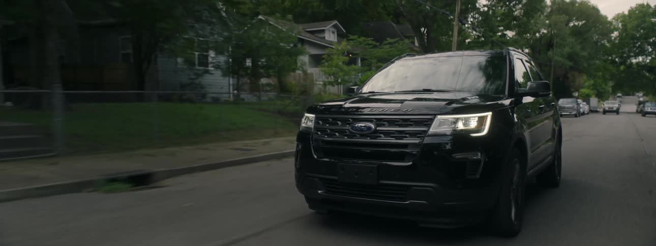 A ford explorer drives in suburban streets