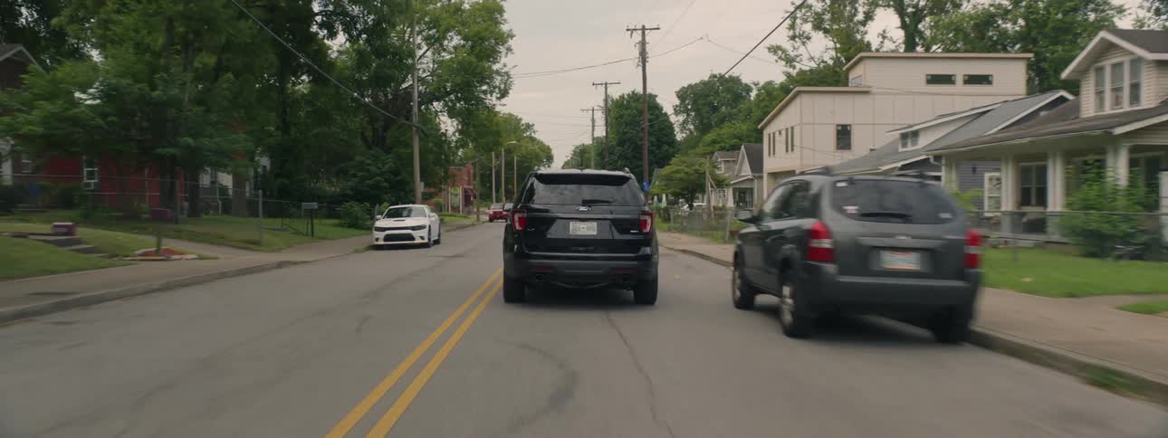 A ford explorer drives in suburban streets