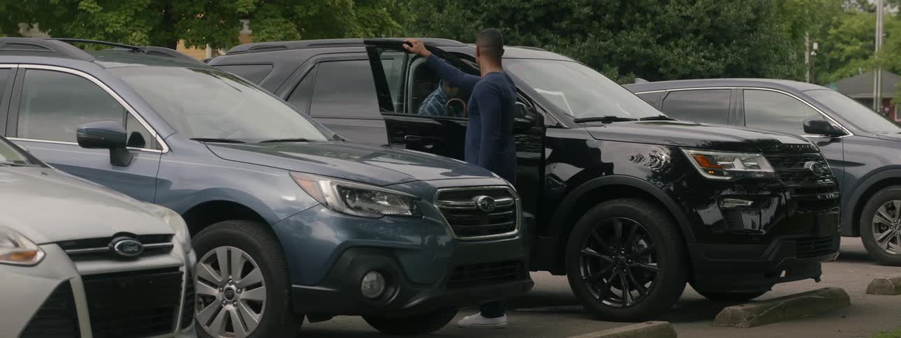 Young man opens suv door for elder