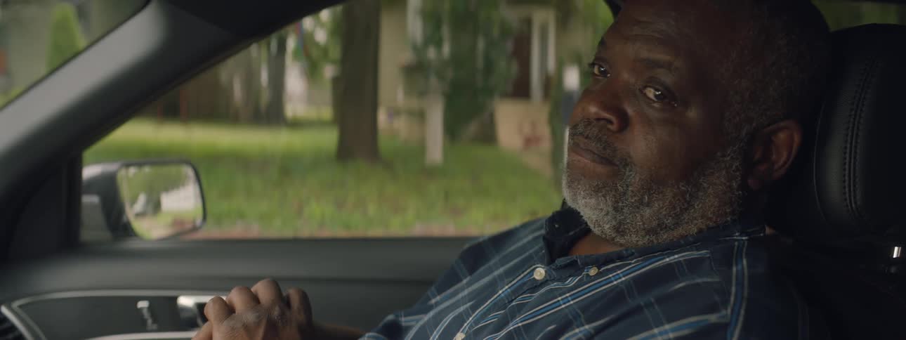 Man sits in a passenger seat of a car waiting