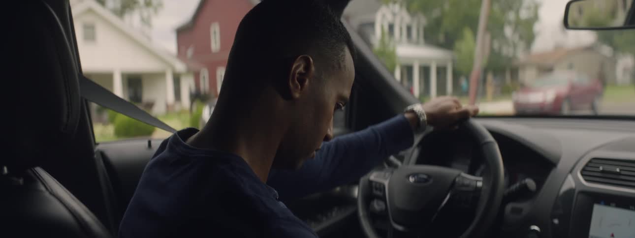 Man sits in car staring out of the windshield