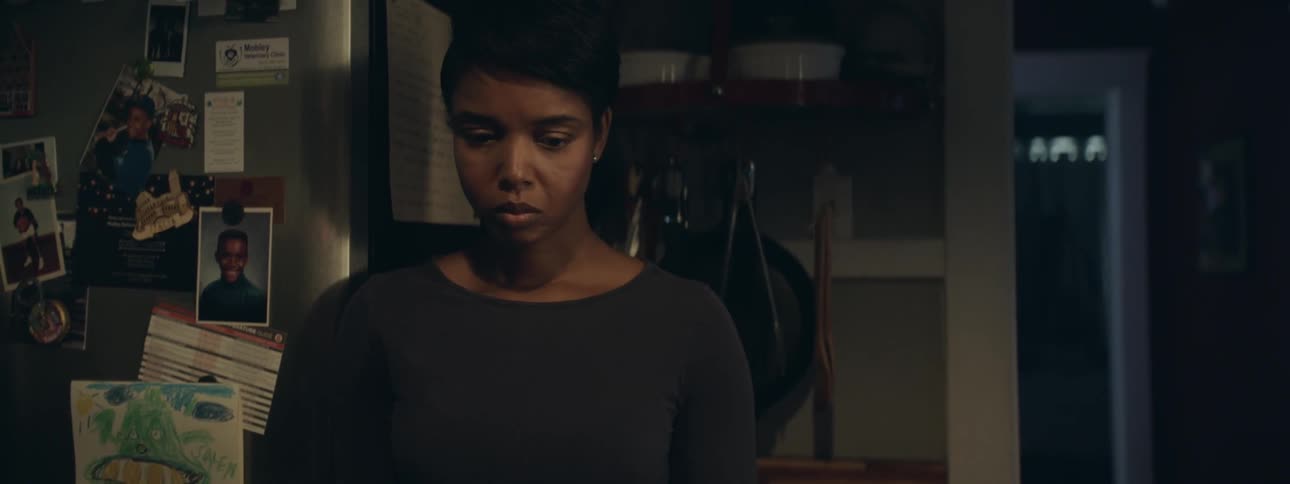 A woman standing beside a fridge