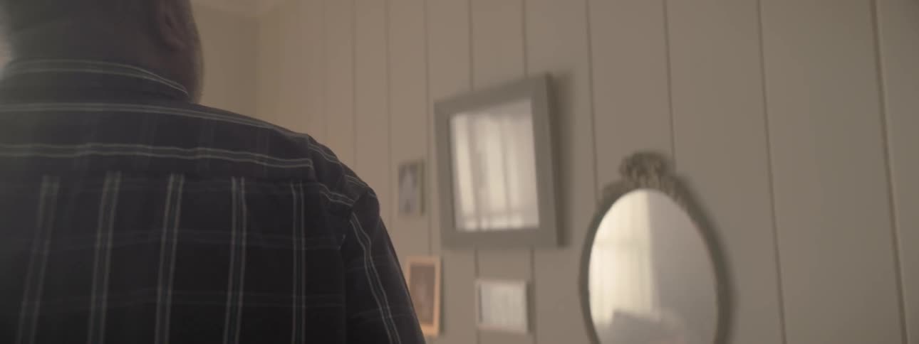 A man walking to a picture on the wall