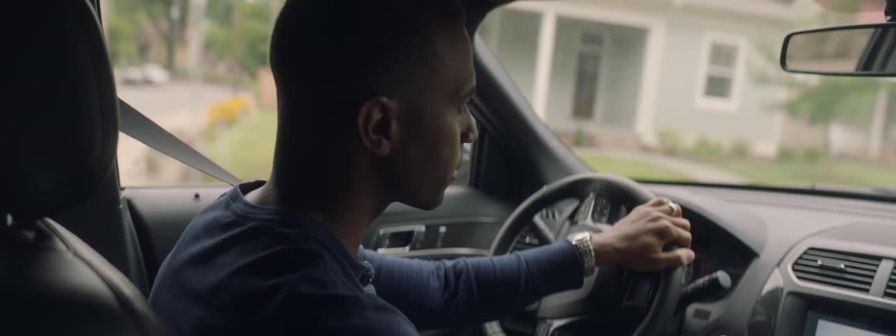 Man turns the steering wheel of a car and drives onto a different street